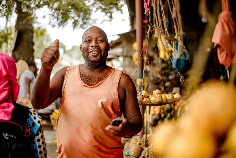 A shop owner working at a laptop behind the counter.